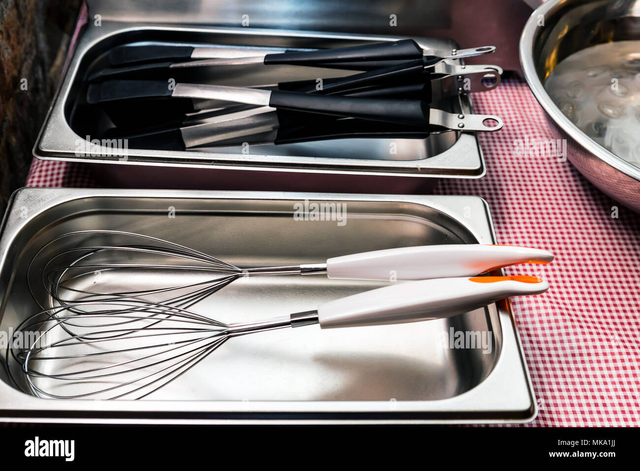 Metal and plastic kitchen tools lie in tray Stock Photo