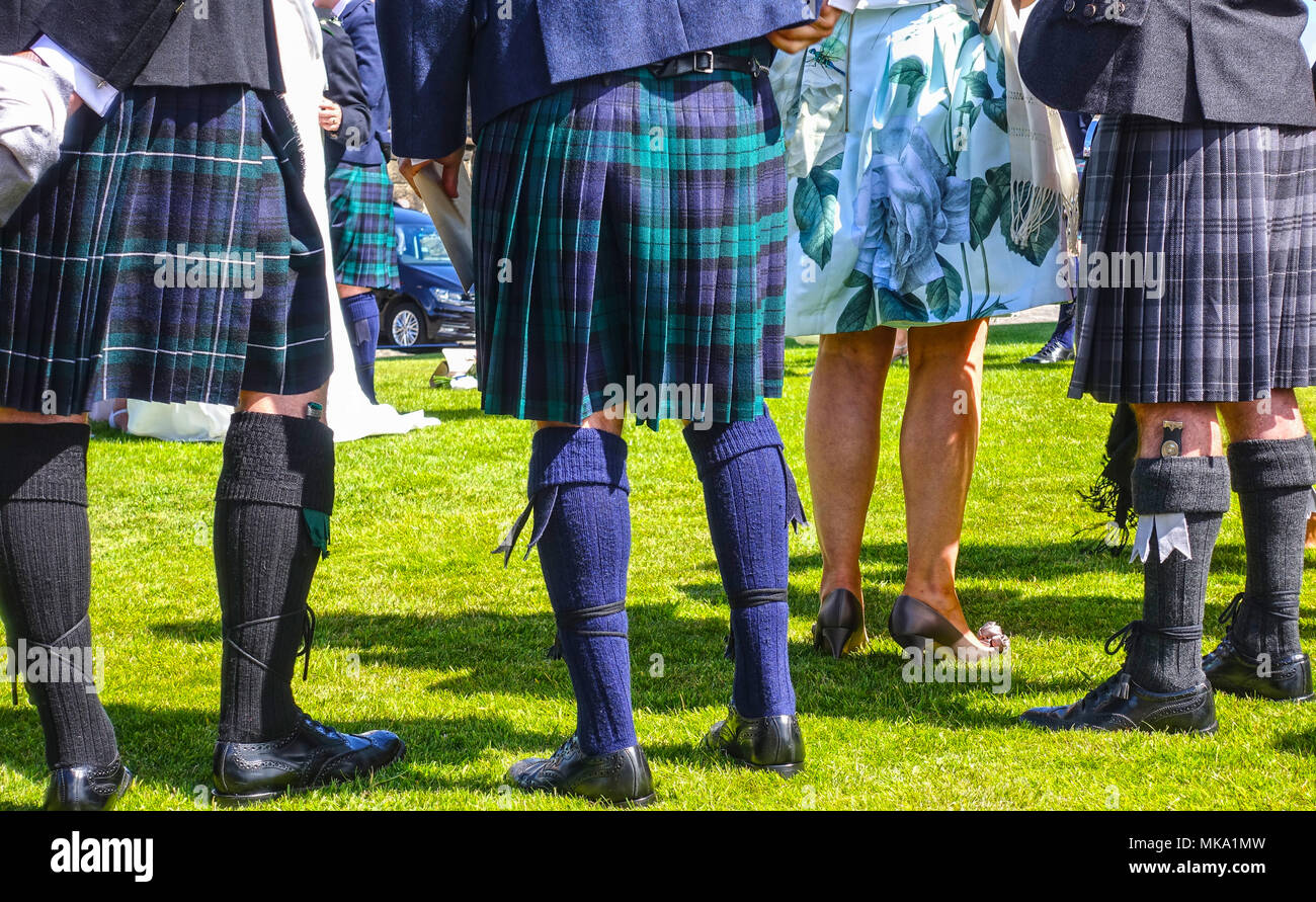 EDINBURGH, SCOTLAND - JULY 14, 2017: People wearing traditional Scottish kilts, stockings, dress shoes and sgian-dubh knifes tucked into stockings. Stock Photo