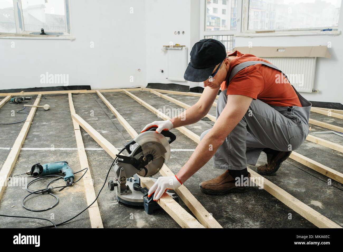Worker cuts wood bars using a circular saw. Stock Photo