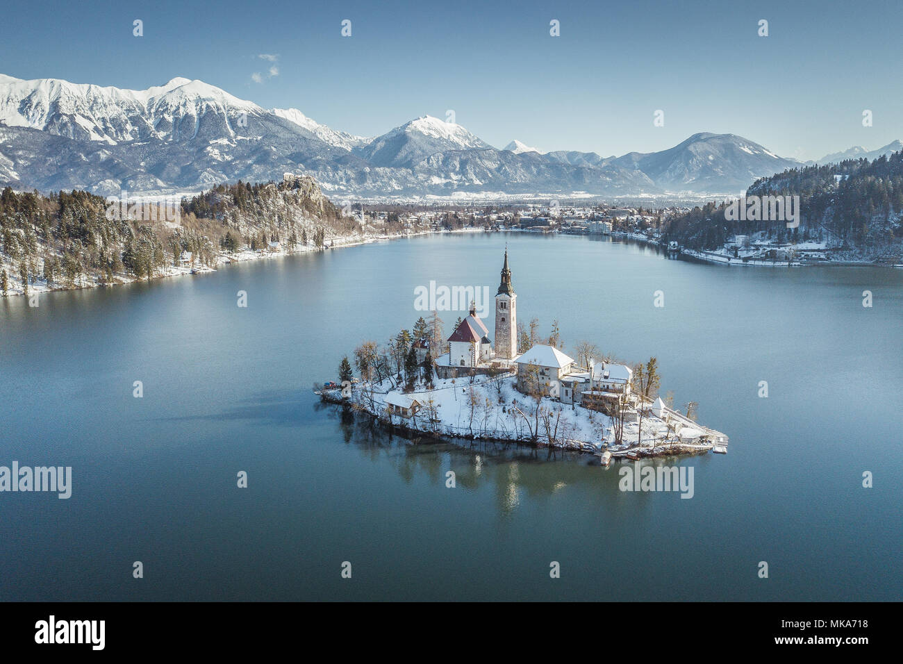 Panoramic view of famous Bled Island (Blejski otok) at scenic Lake Bled with Bled Castle (Blejski grad) and Julian Alps in the background on a beautif Stock Photo