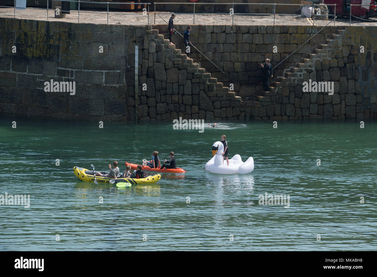 Mousehole, Cornwall, UK. 7th May 2018. UK Weather. The temperature soared this afternoon at Mousehole in Cornwall, with children making the most of the harbour waters. Credit: Simon Maycock/Alamy Live News Stock Photo