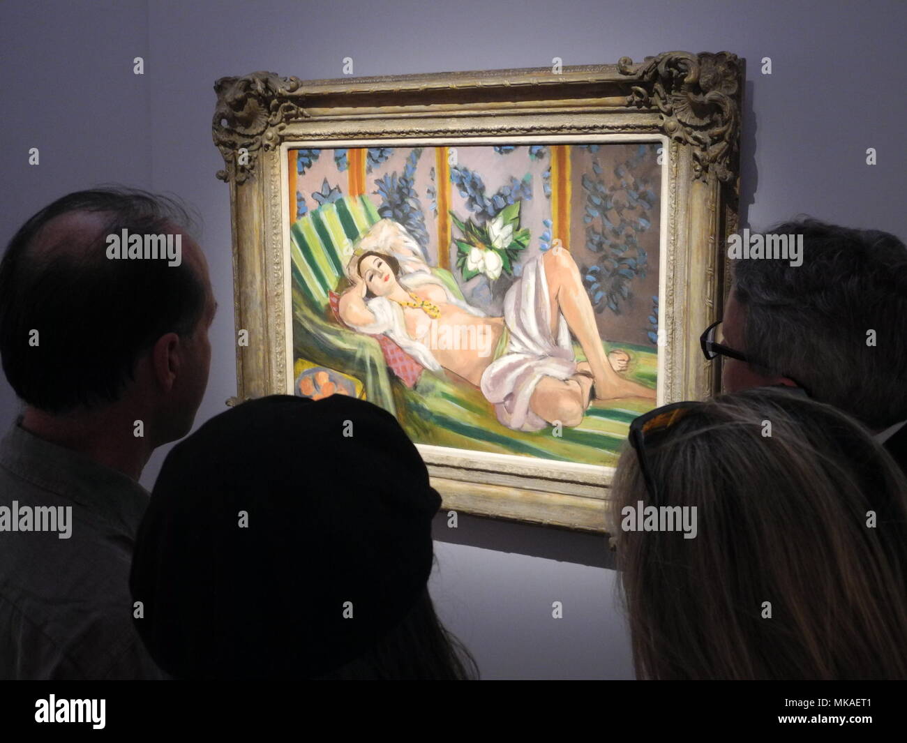 04 May 2018, US, New York: Visitors looking at the painting "Odalisque  couchee aux magnolias" by Henri Matisse, which was part of the private  collection of deceased US billionaire David Rockefeller, and