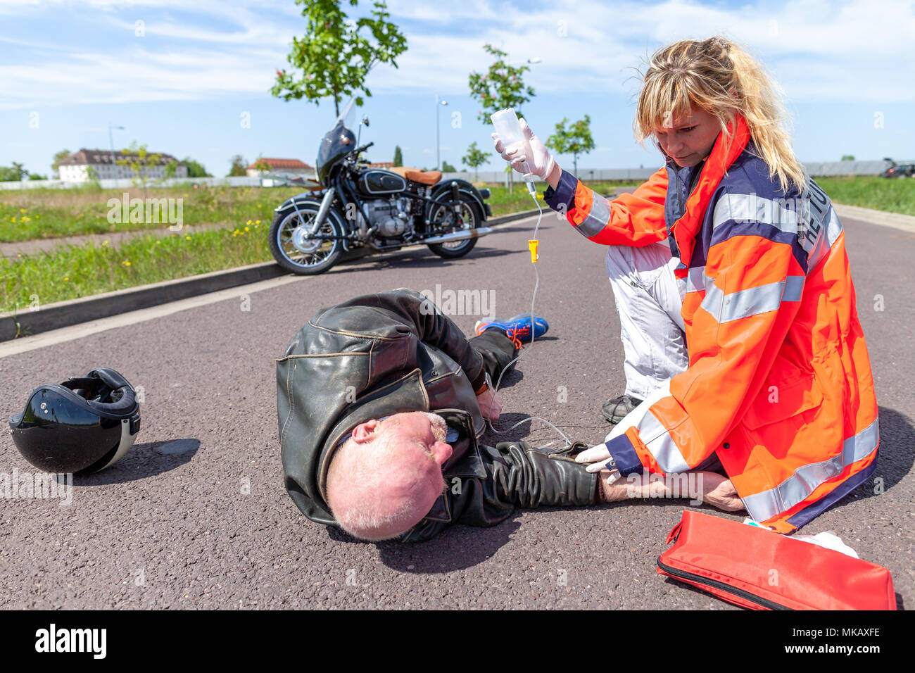 A german paramedic helps an injured motorcyclist. Rettungsdienst is the