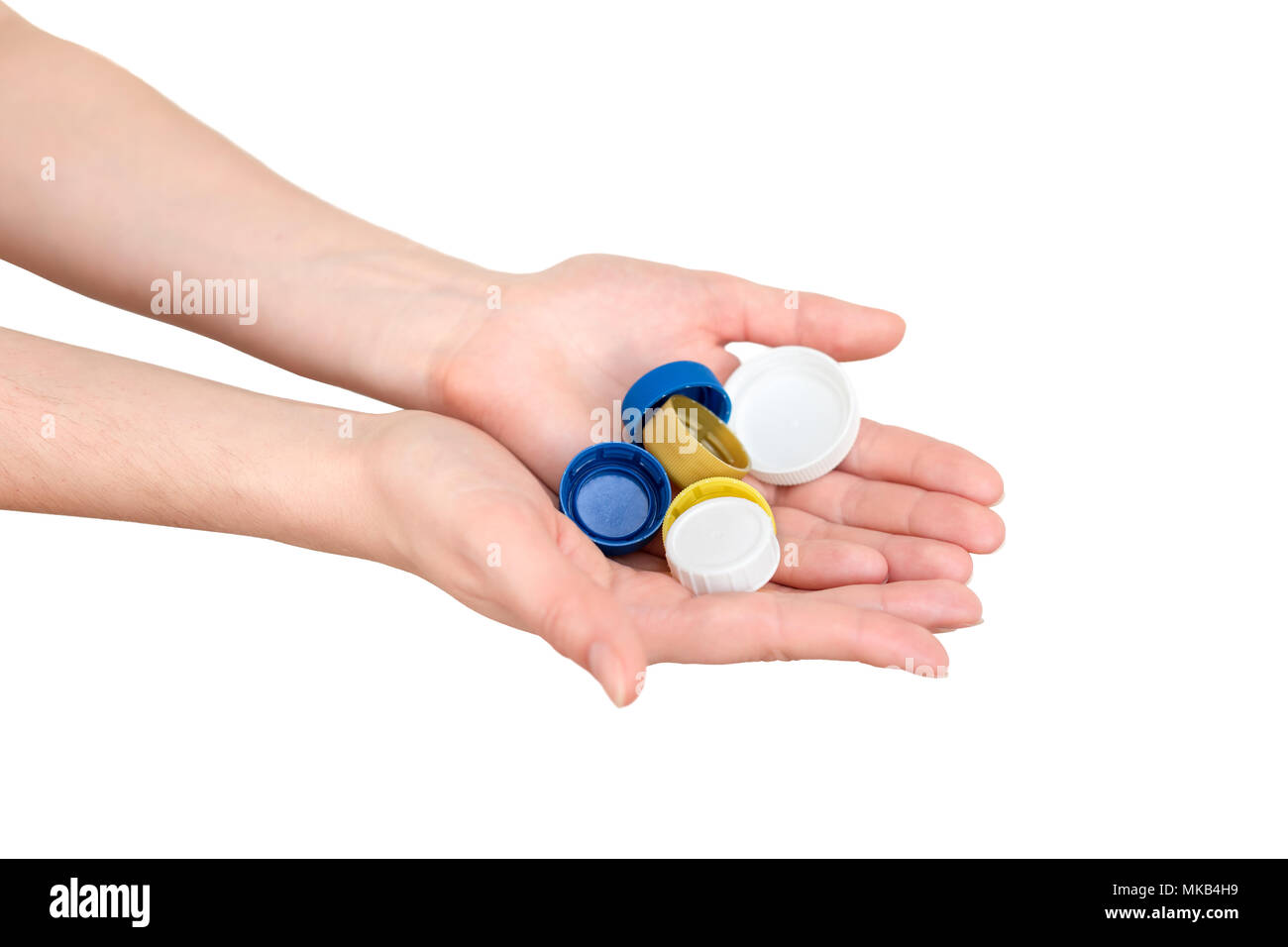 Female hand holding plastic bottle caps. Two hands with plastic lids