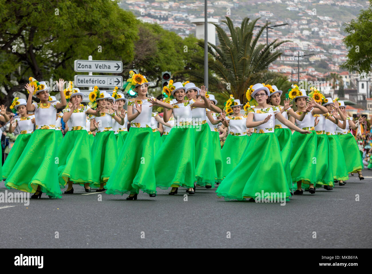 Funchal; Madeira; Portugal - April 22; 2018: A group of girls in colorful dresses with sunflowers motifs are dancing at Madeira Flower Festival Parade Stock Photo