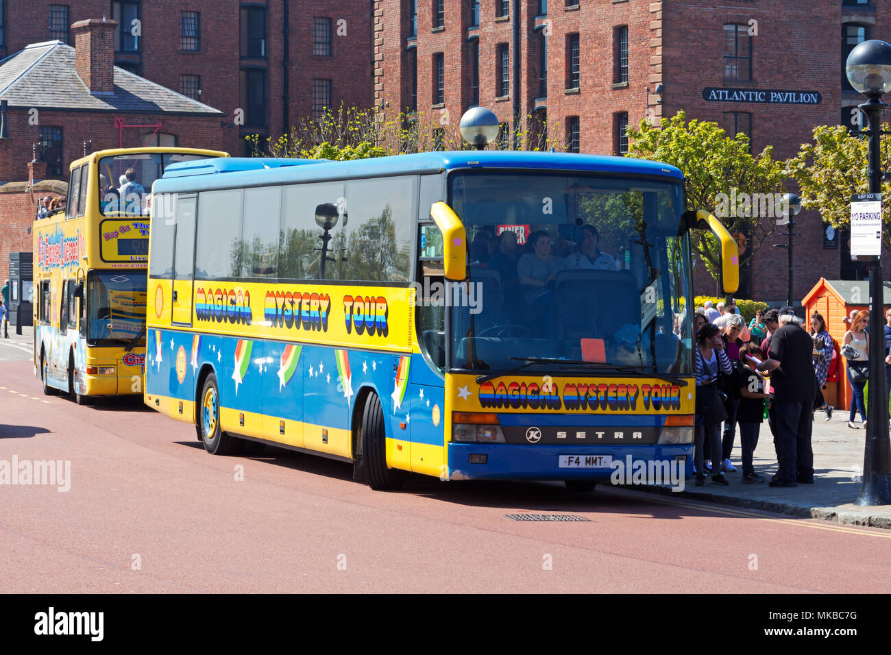 The colourful Magical Mystery Tour bus picking up tourists at the Albert Dock before driving around Liverpool's various Beatles landmarks. Stock Photo