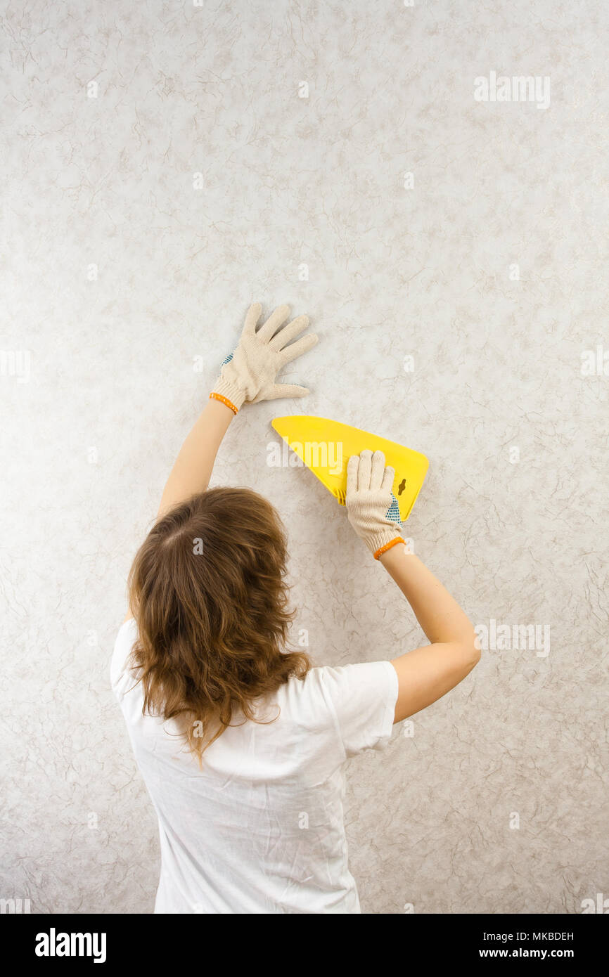 woman smoothing wallpaper with spatula on the wall Stock Photo Alamy