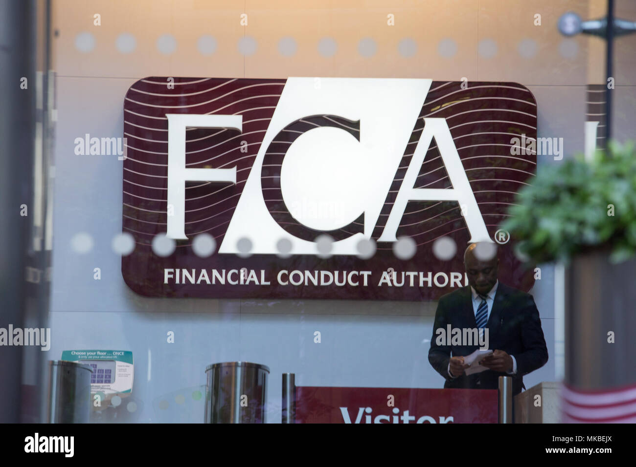 Financial Conduct Authority (FCA) offices, North Colonnade, Docklands, London. Reception with security guard standing next to visitor gate Stock Photo
