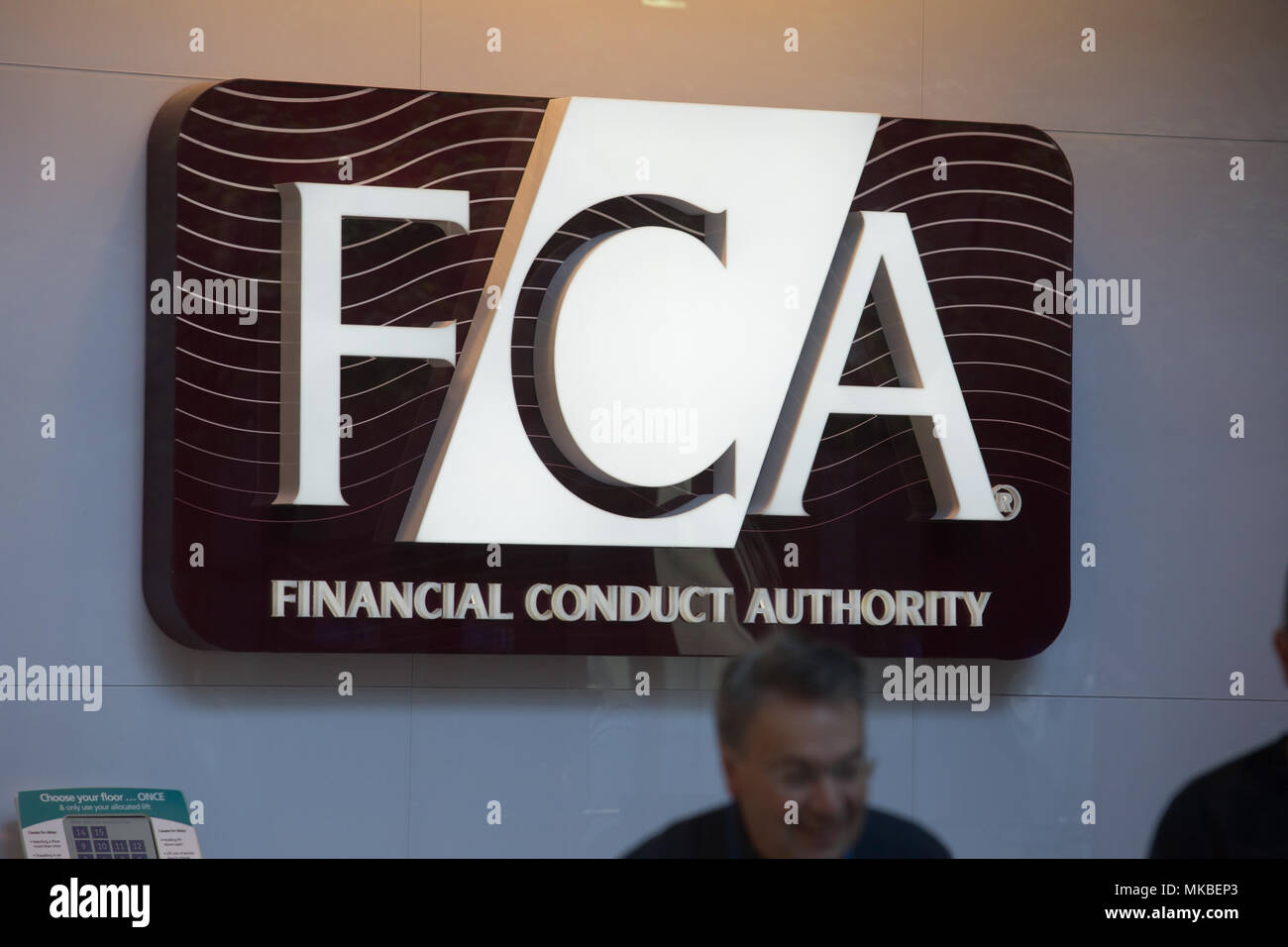 Financial Conduct Authority (FCA) offices, North Colonnade, Docklands, London. Employees exiting through security gates at lunchtime. Stock Photo
