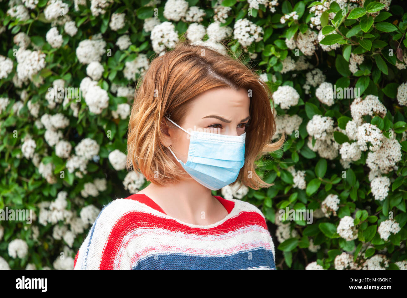 Spring Allergies. Woman wearing protect mask from pollen allergy Stock