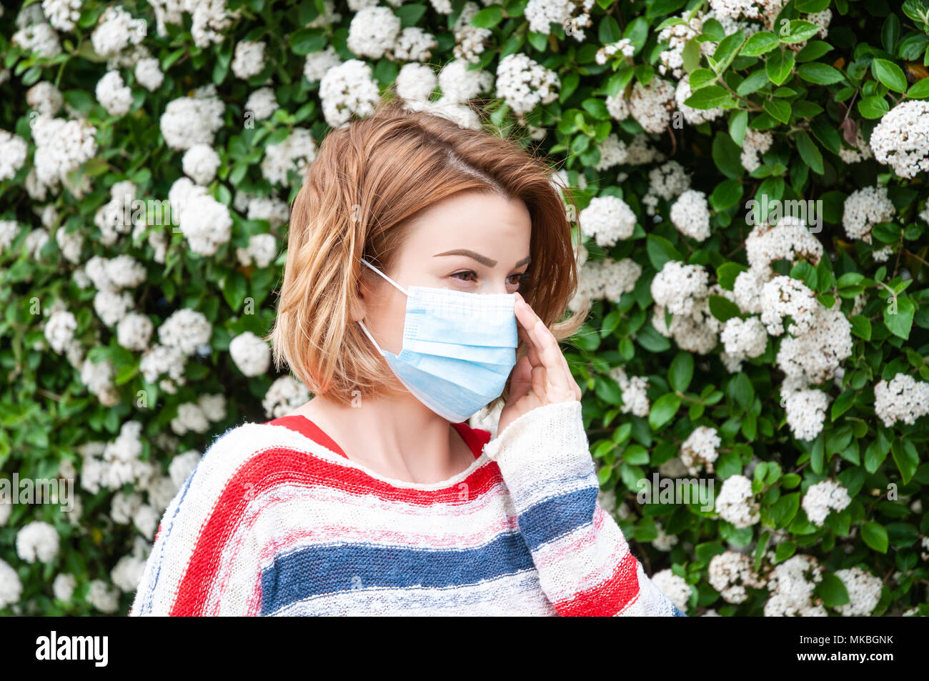 Spring Allergies. Woman wearing protect mask from pollen allergy Stock