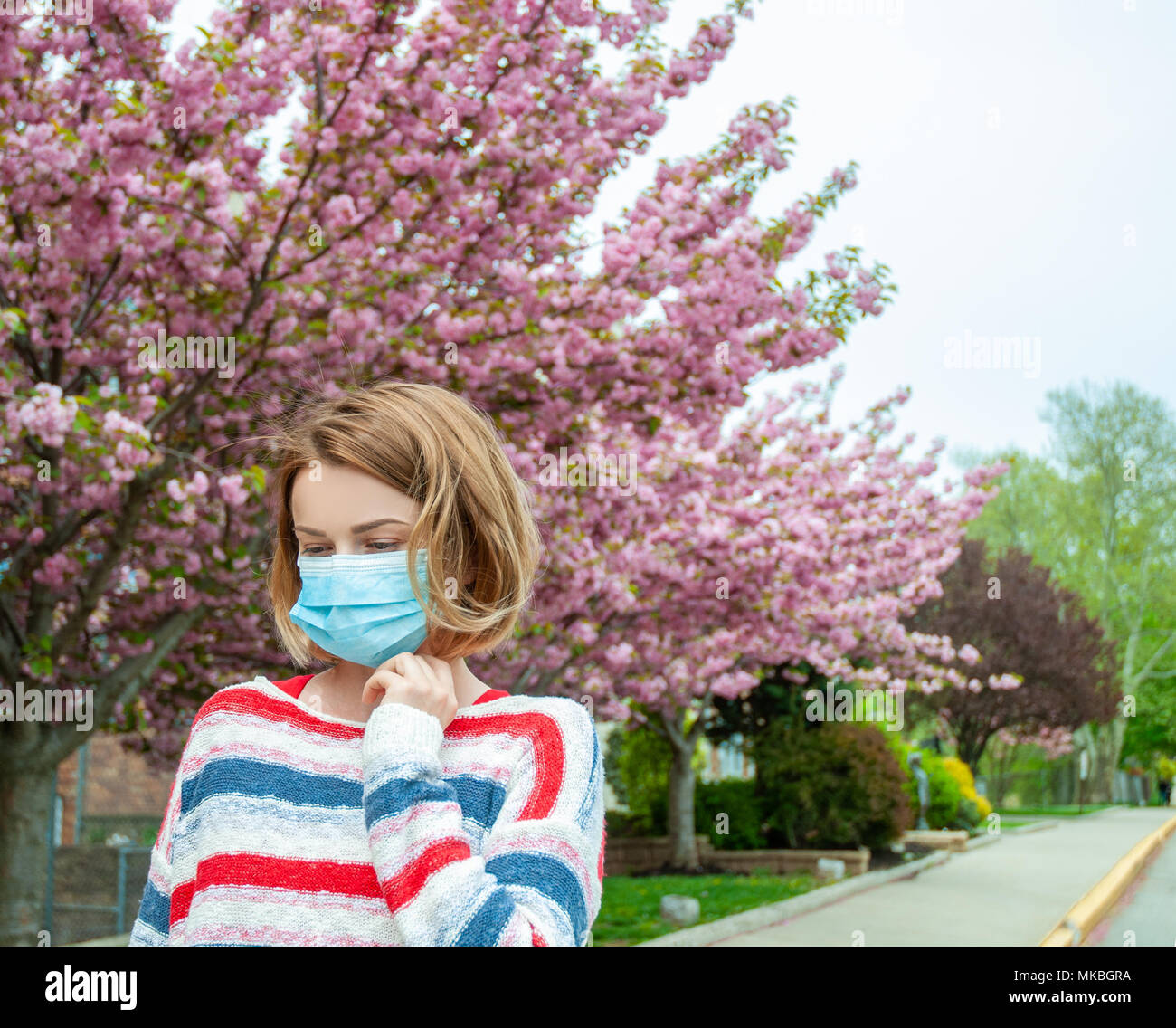 Spring Allergies. Woman wearing protect mask from pollen allergy Stock