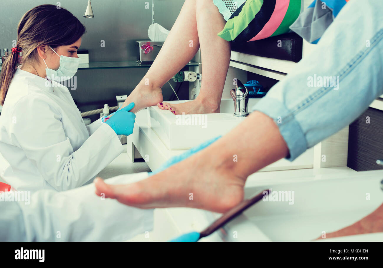 Nail pedicure technician performing procedure for foot care in nail spa