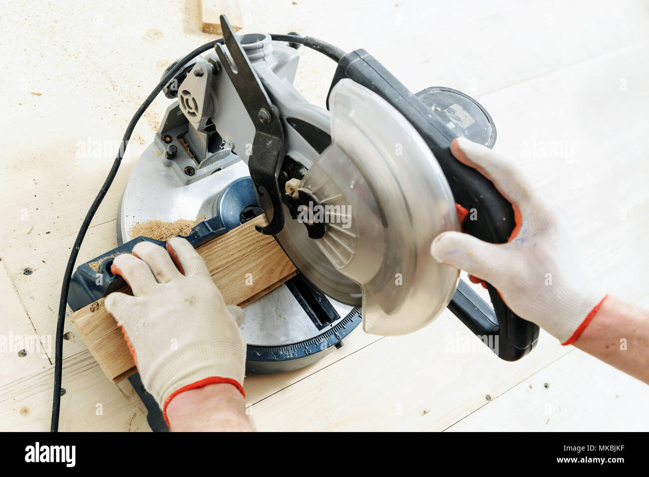 Worker cuts wooden floorboards using a circular saw Stock Photo Alamy