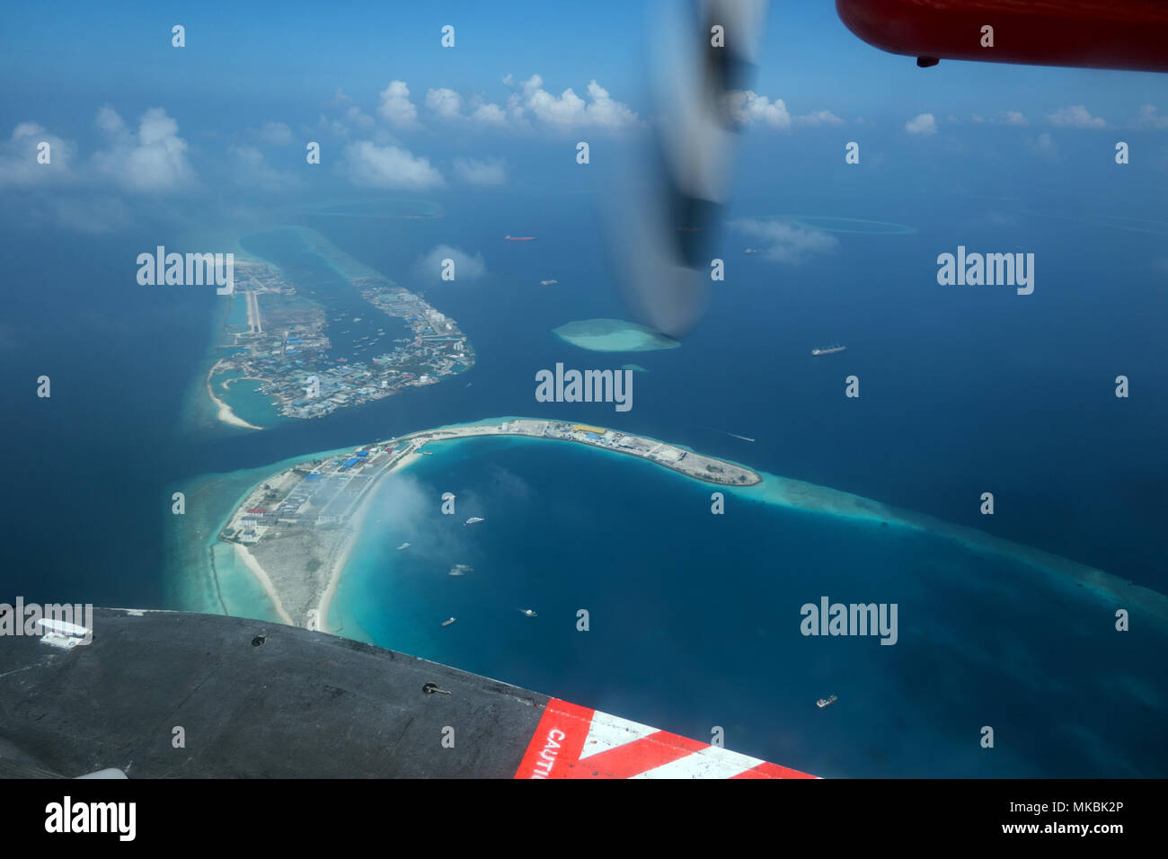 Aerial view of atolls, islands in Maldives, Asia, Indian Ocean. Archipelago, resort in tropical paradise seen from sky on airplane, plane, seaplane, f Stock Photo