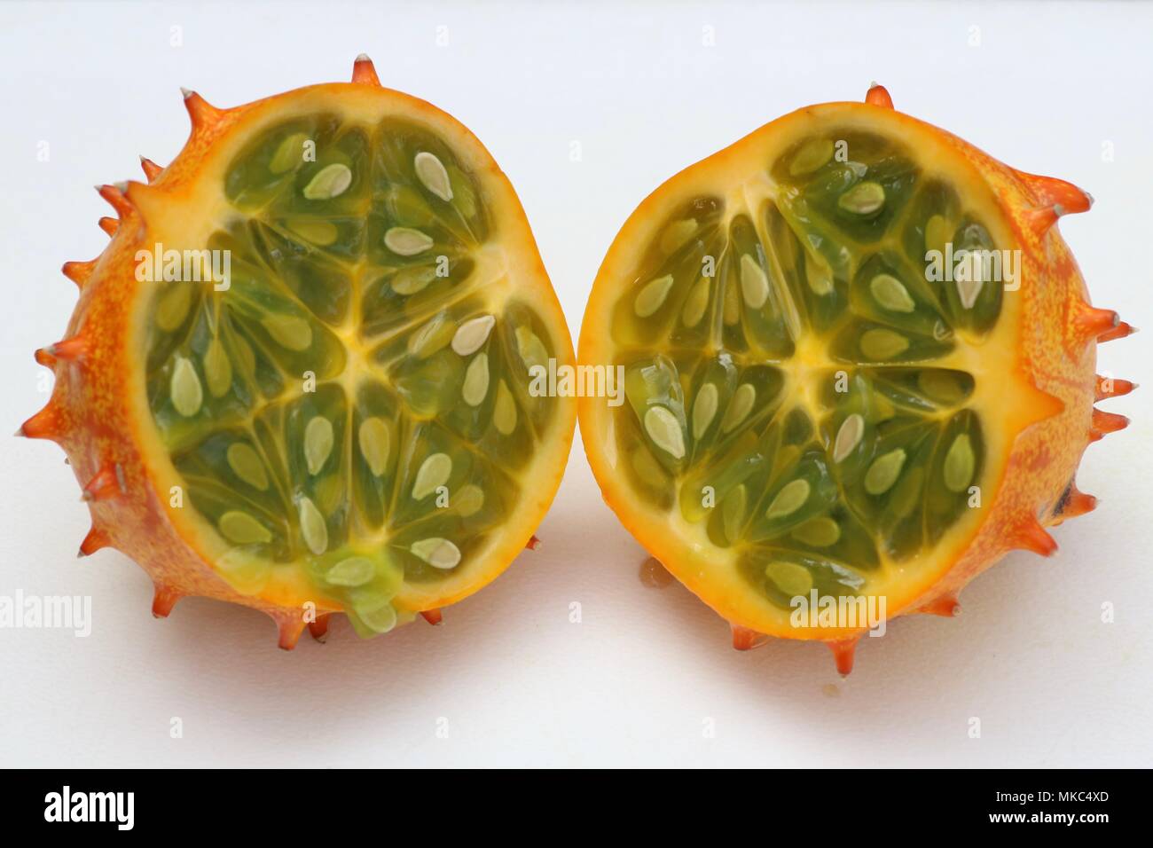 Cut open kiwano horned melon against a white background Stock Photo