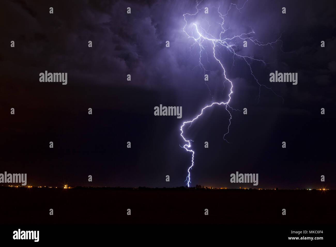 An energetic lightning bolt striking in a late night thunderstorm over Casa Grande, Arizona Stock Photo