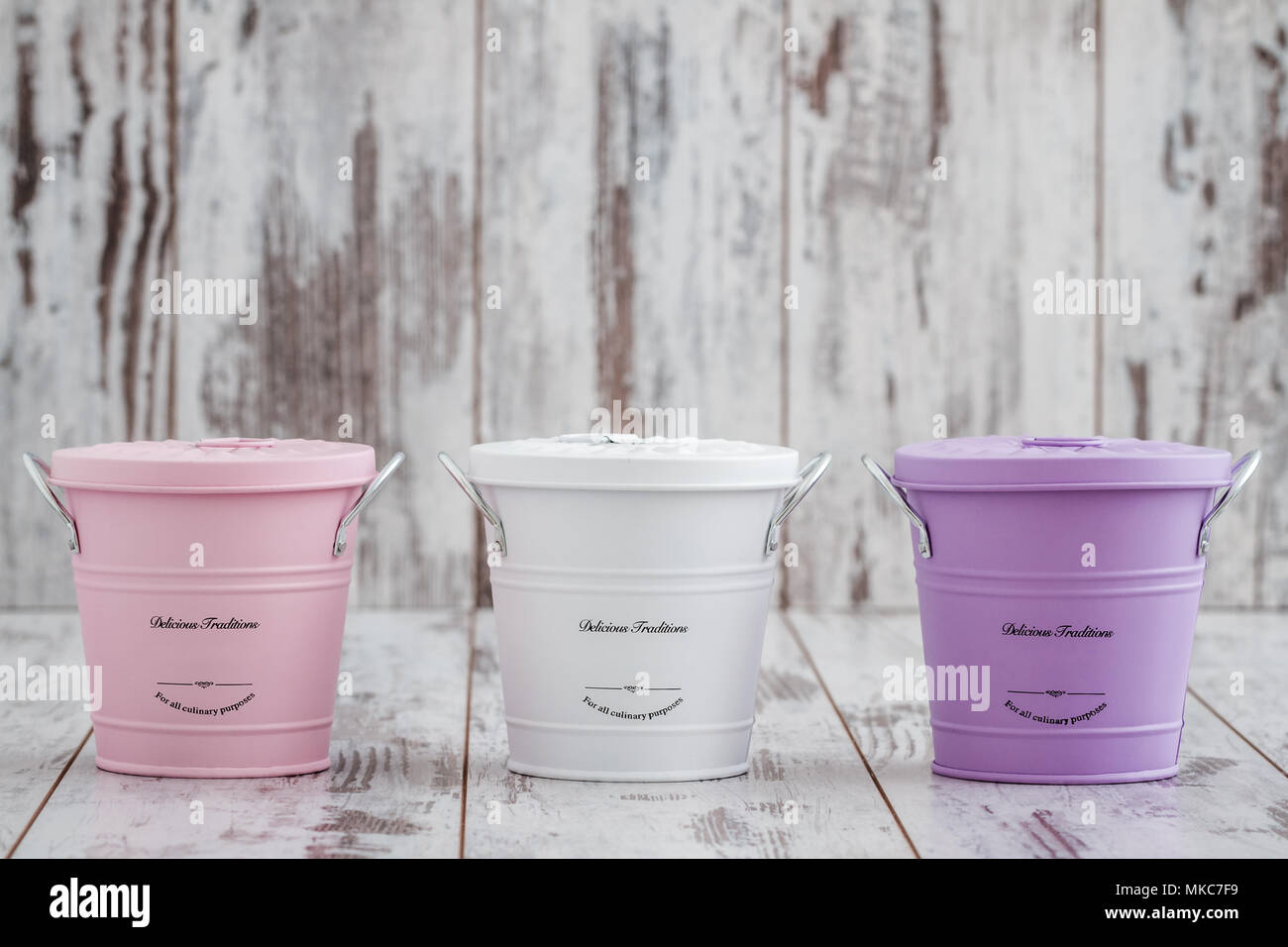 Vintage colorful potato onion and garlic storage containers on white