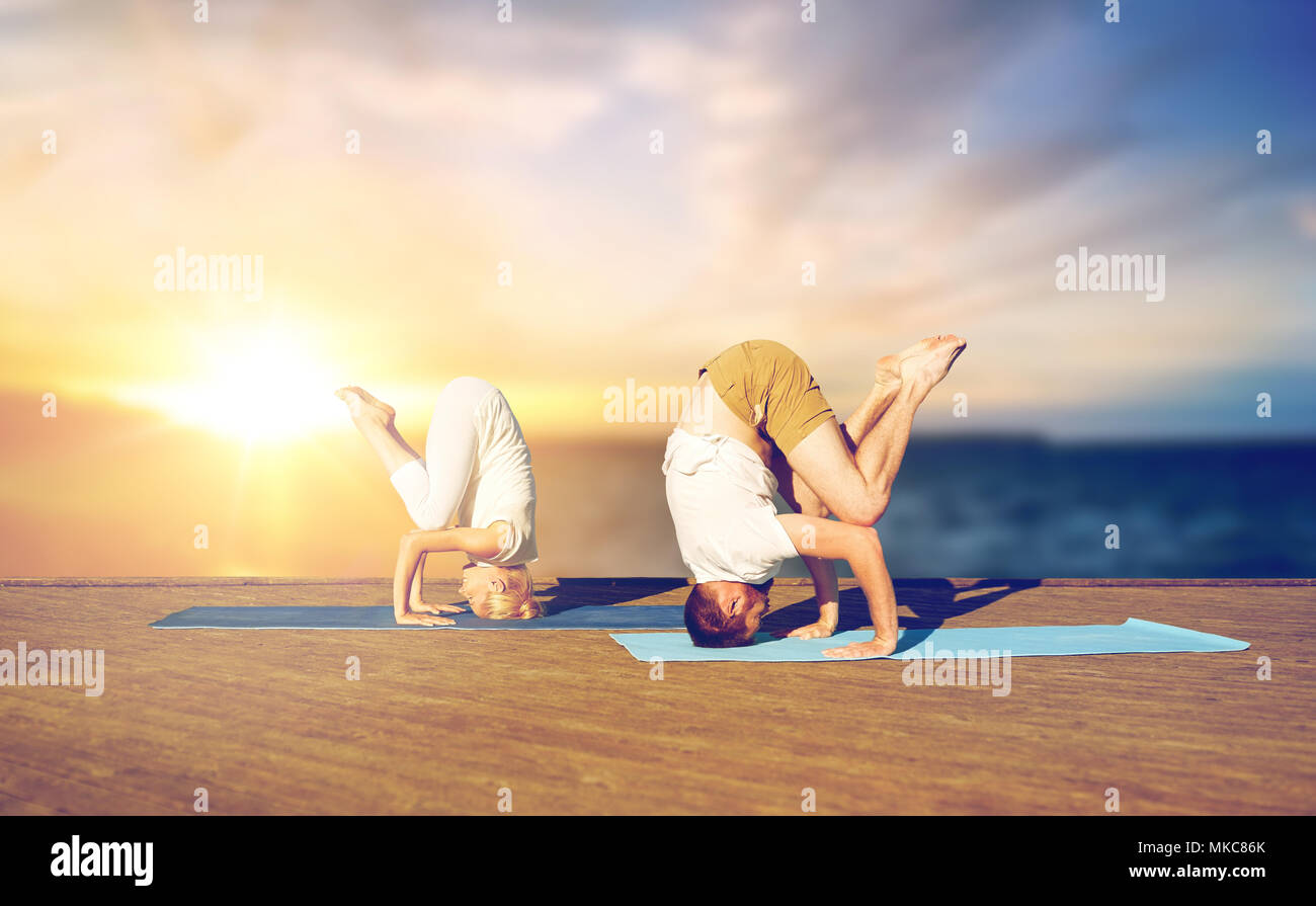couple doing yoga headstand outdoors Stock Photo