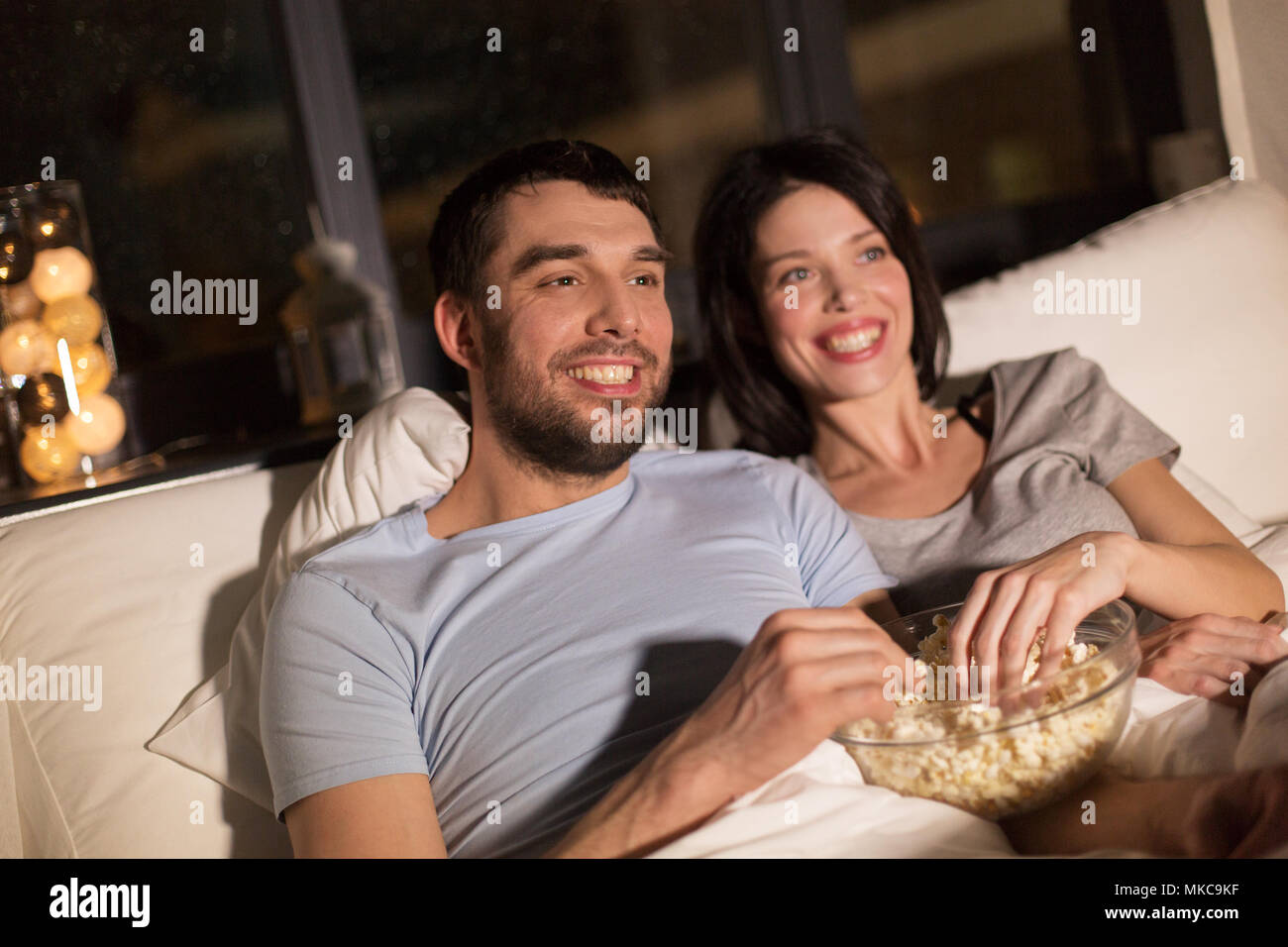 couple with popcorn watching tv at night at home Stock Photo - Alamy