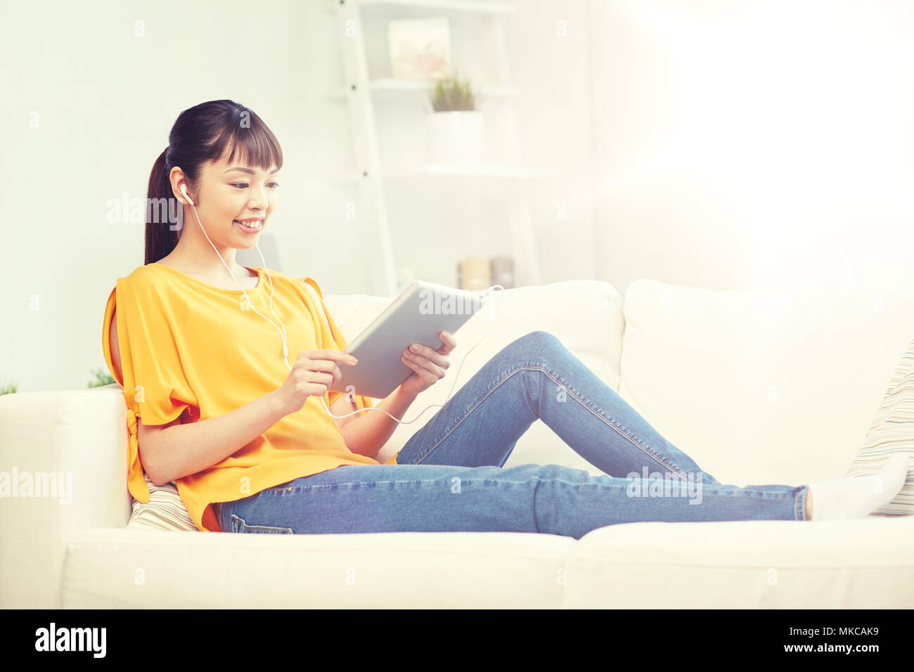 happy asian woman with tablet pc and earphones Stock Photo - Alamy
