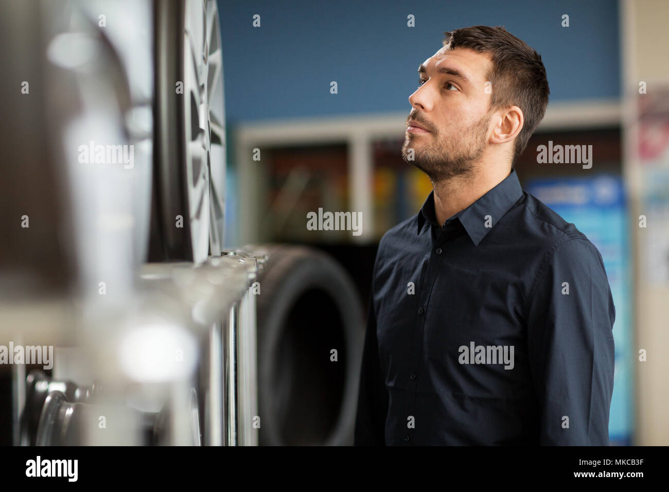 male customer choosing wheel rims at car service Stock Photo - Alamy