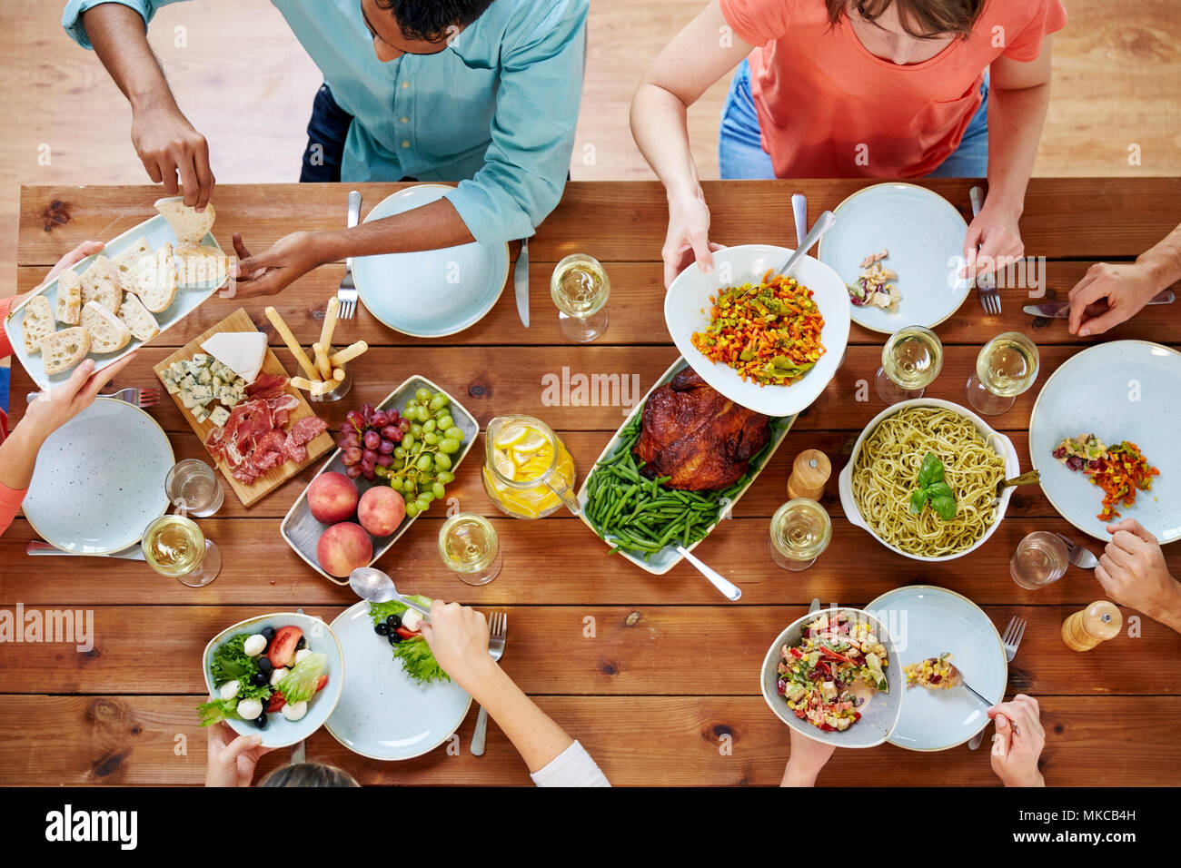 group of people eating at table with food Stock Photo - Alamy