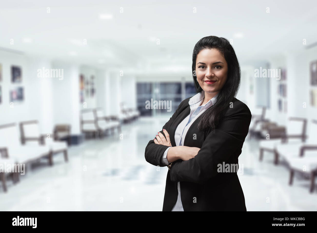 Smiling bank manager welcoming warm personality bright big smile in large building Stock Photo