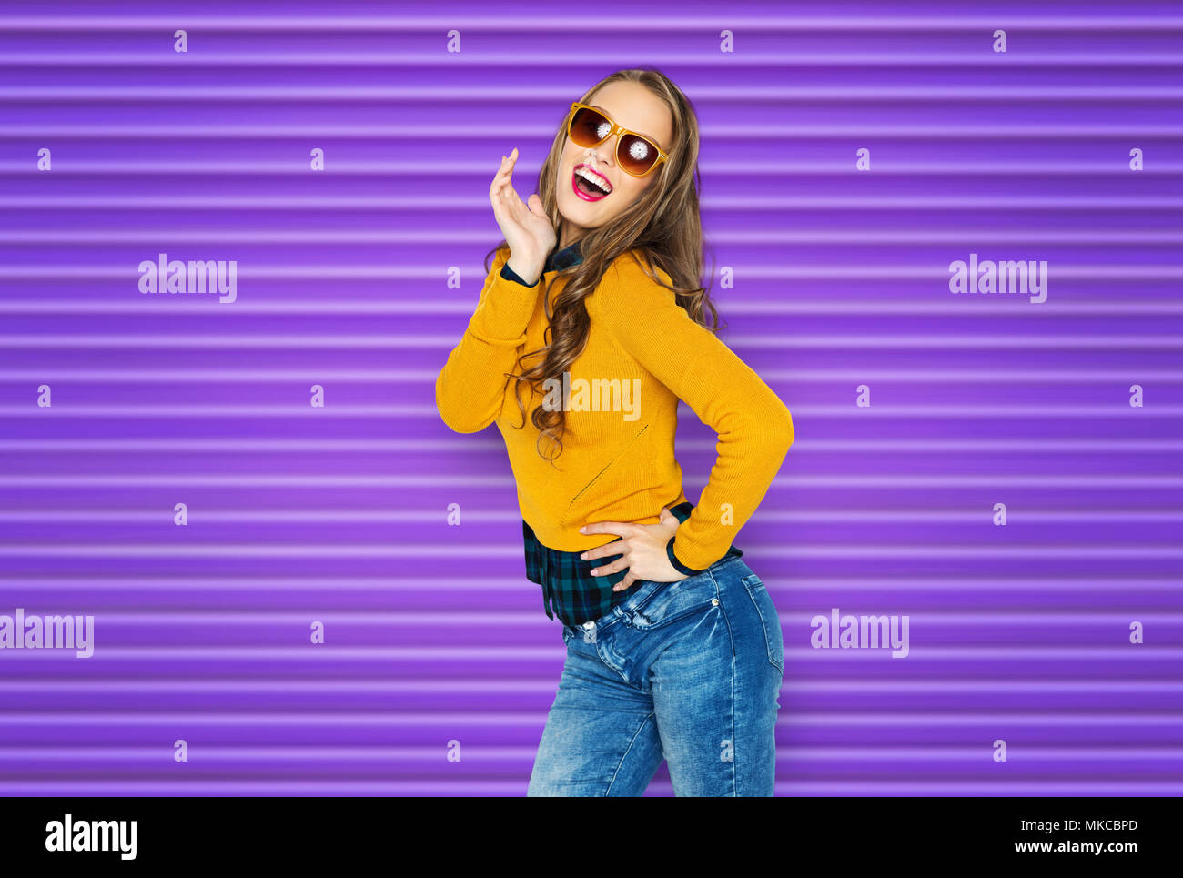 Young lady or teen girl in jeans and yellow t-shirt has fun taking