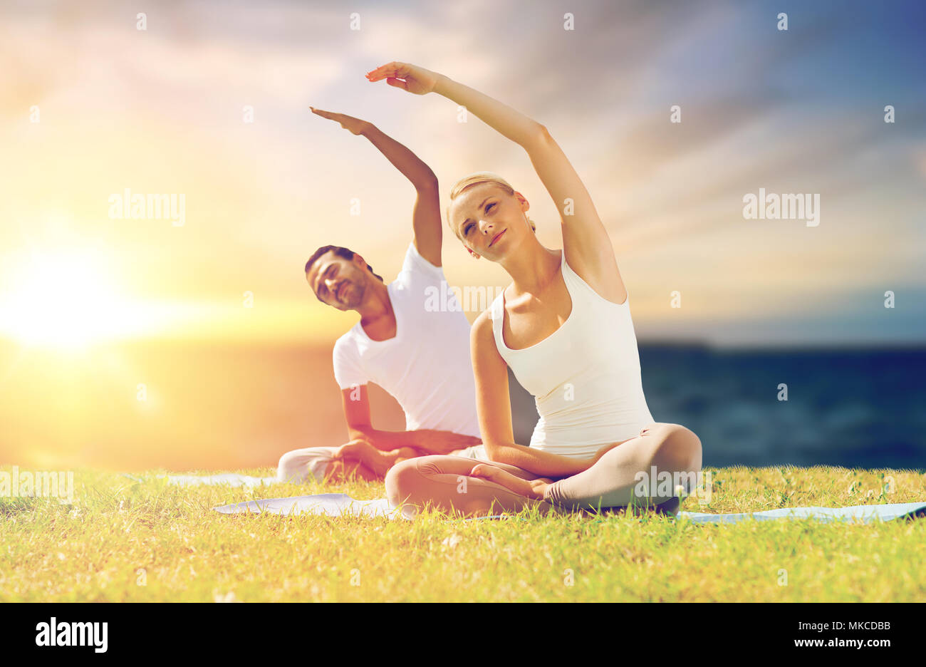 couple making yoga exercises outdoors Stock Photo
