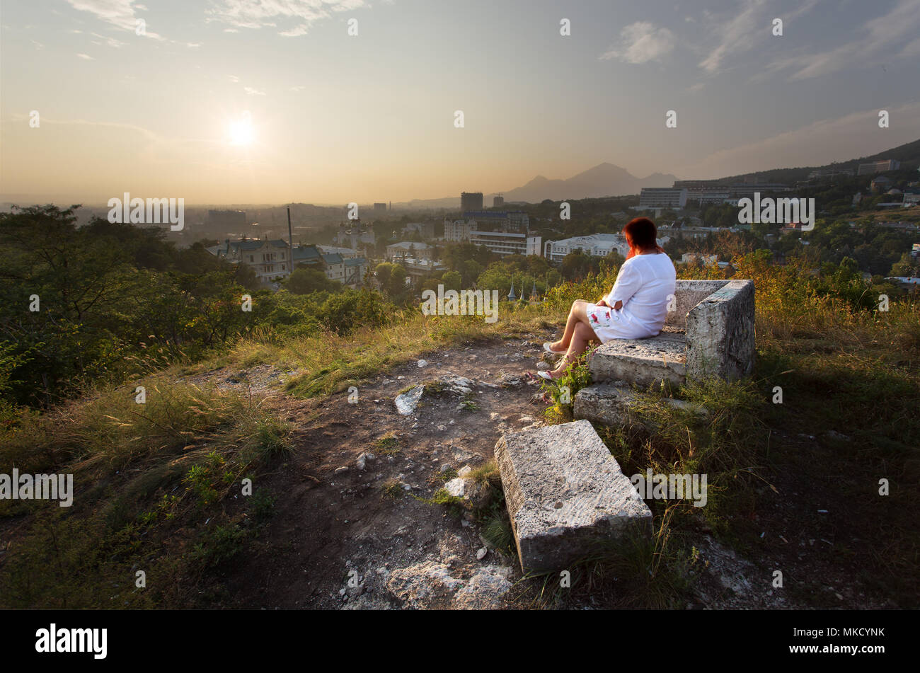 Woman in white relaxing and overlooking the city of Pyatigorsk and Tsvetnik Park, Pyatigorsk, Russia Stock Photo