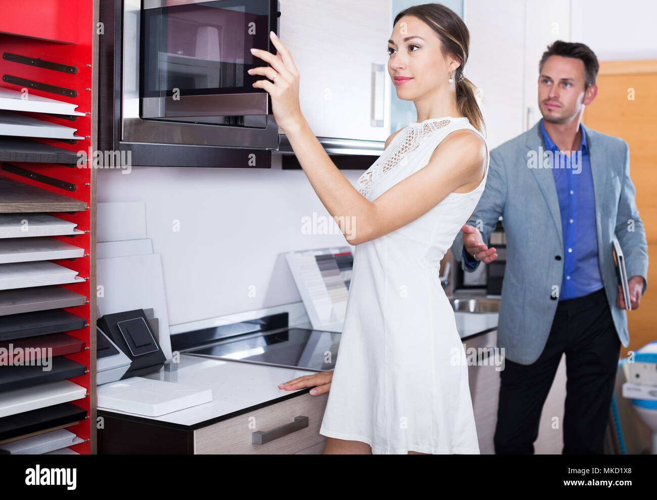 Successful positive seller and glad woman at kitchen furniture