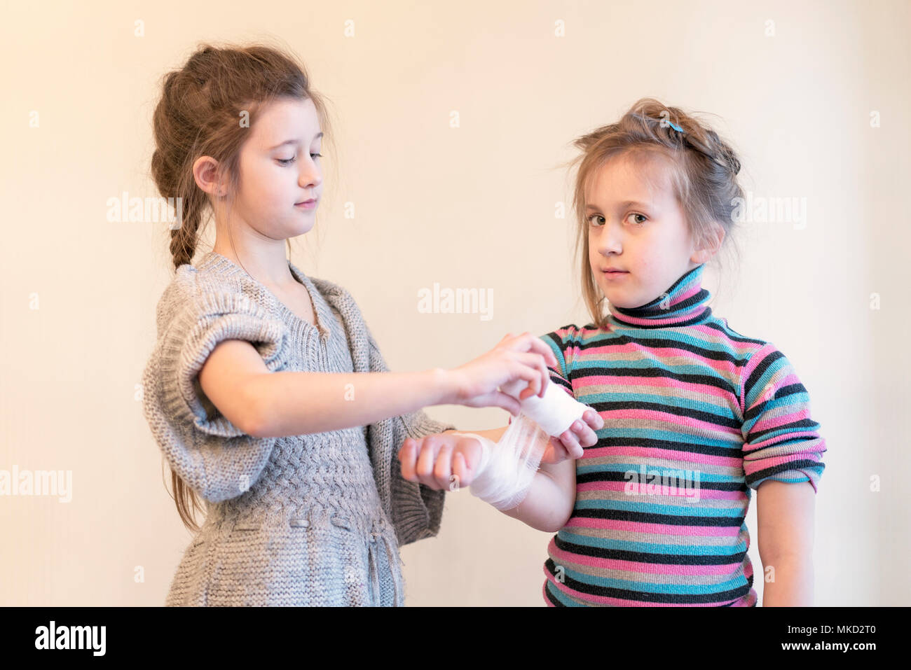 The Girl Bending Her Sister S Hand Two Girls Play Doctor Bandage