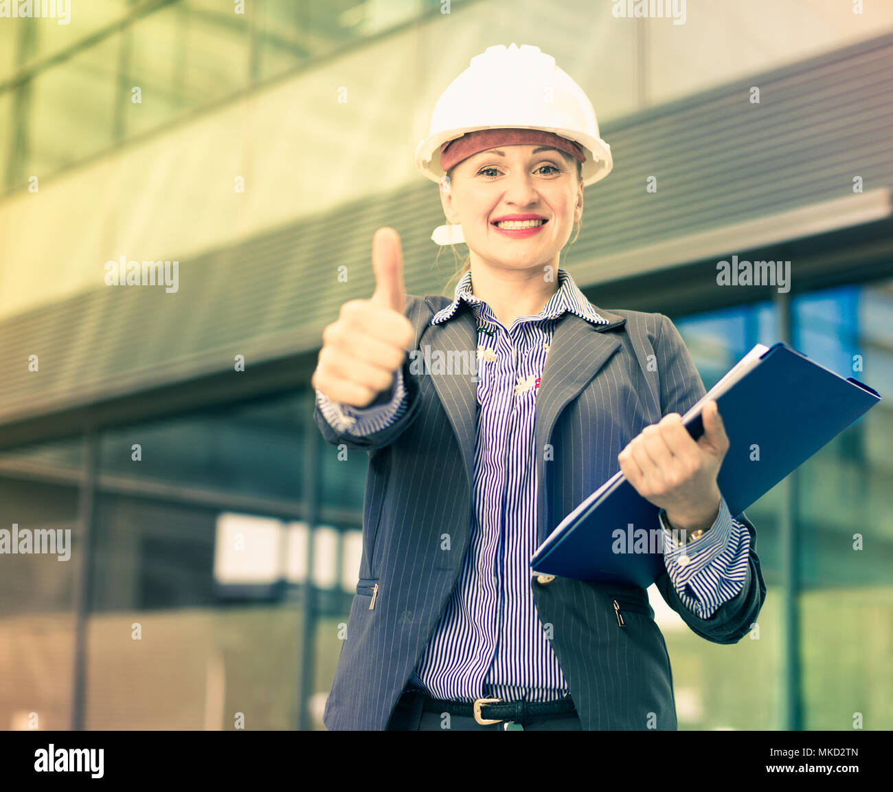 Professional woman in jacket and helmet working with documents Stock ...