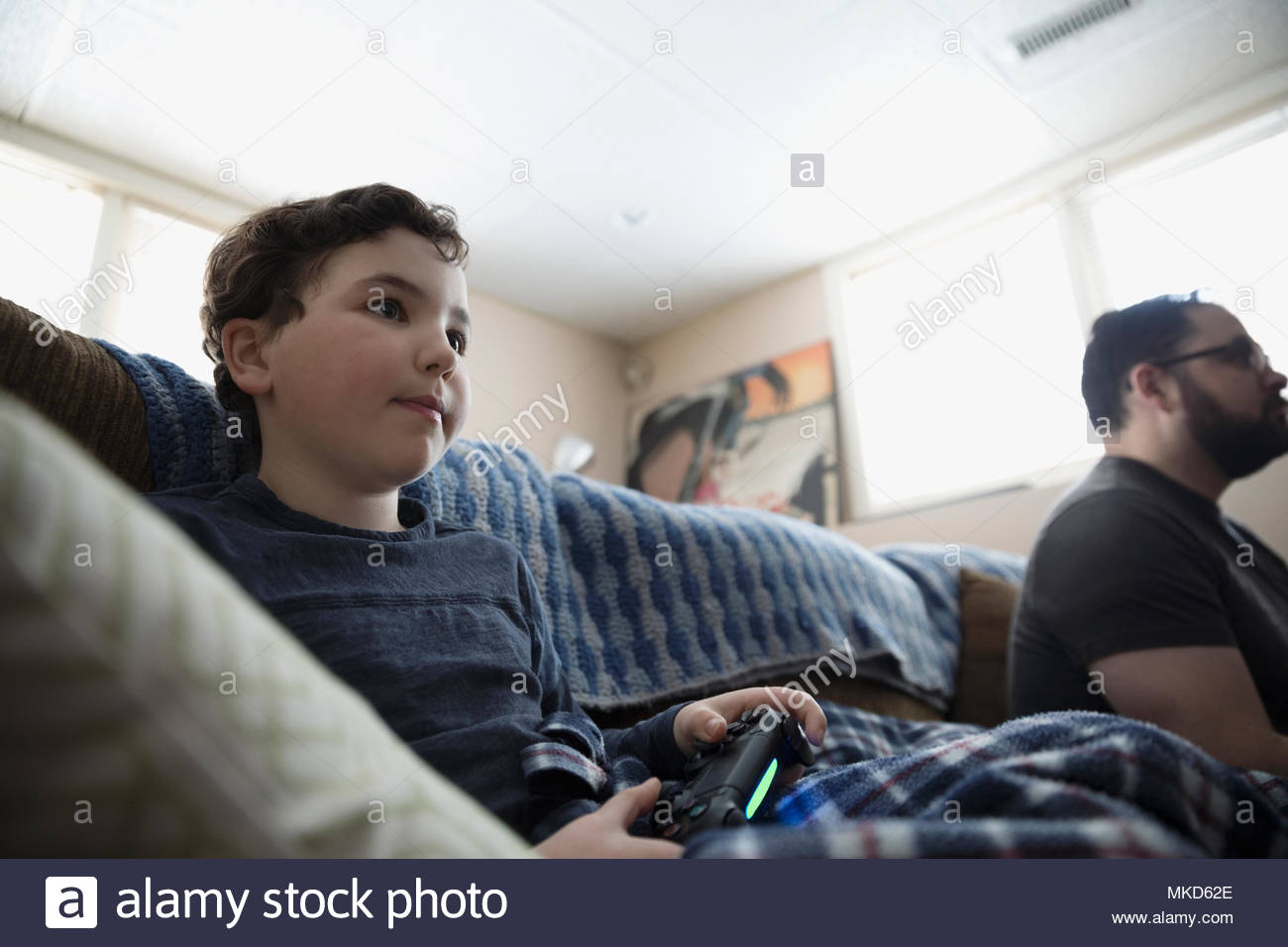 Boy playing video game on living room sofa Stock Photo Alamy