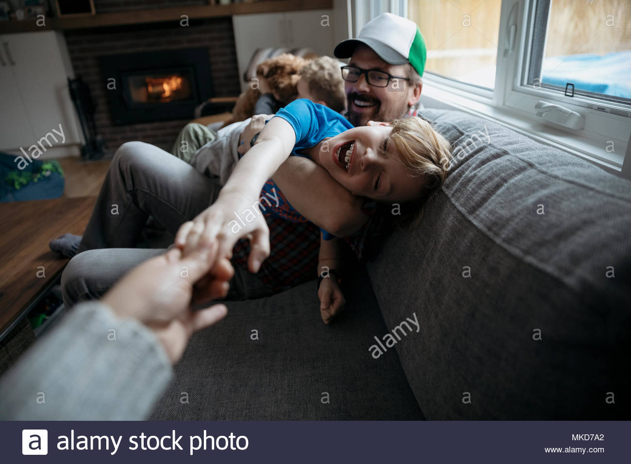 Personal perspective family playing on living room sofa Stock Photo