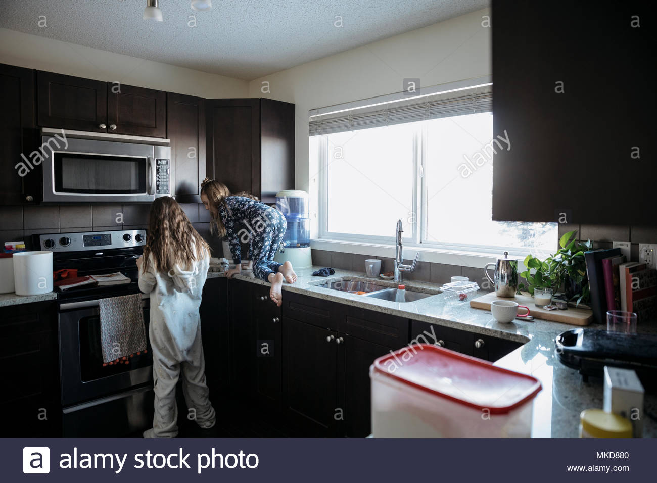 Sisters in pajamas in kitchen Stock Photo