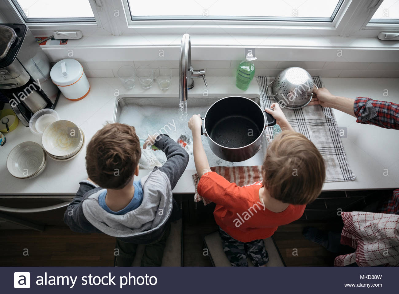 Overhead view brothers doing dishes at kitchen sink Stock Photo Alamy