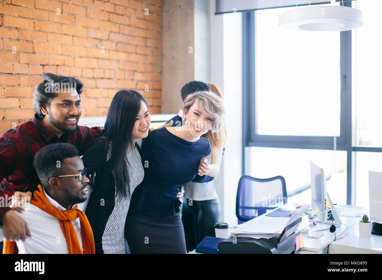 hugging team is chatting online with colleagues on the Net Stock Photo
