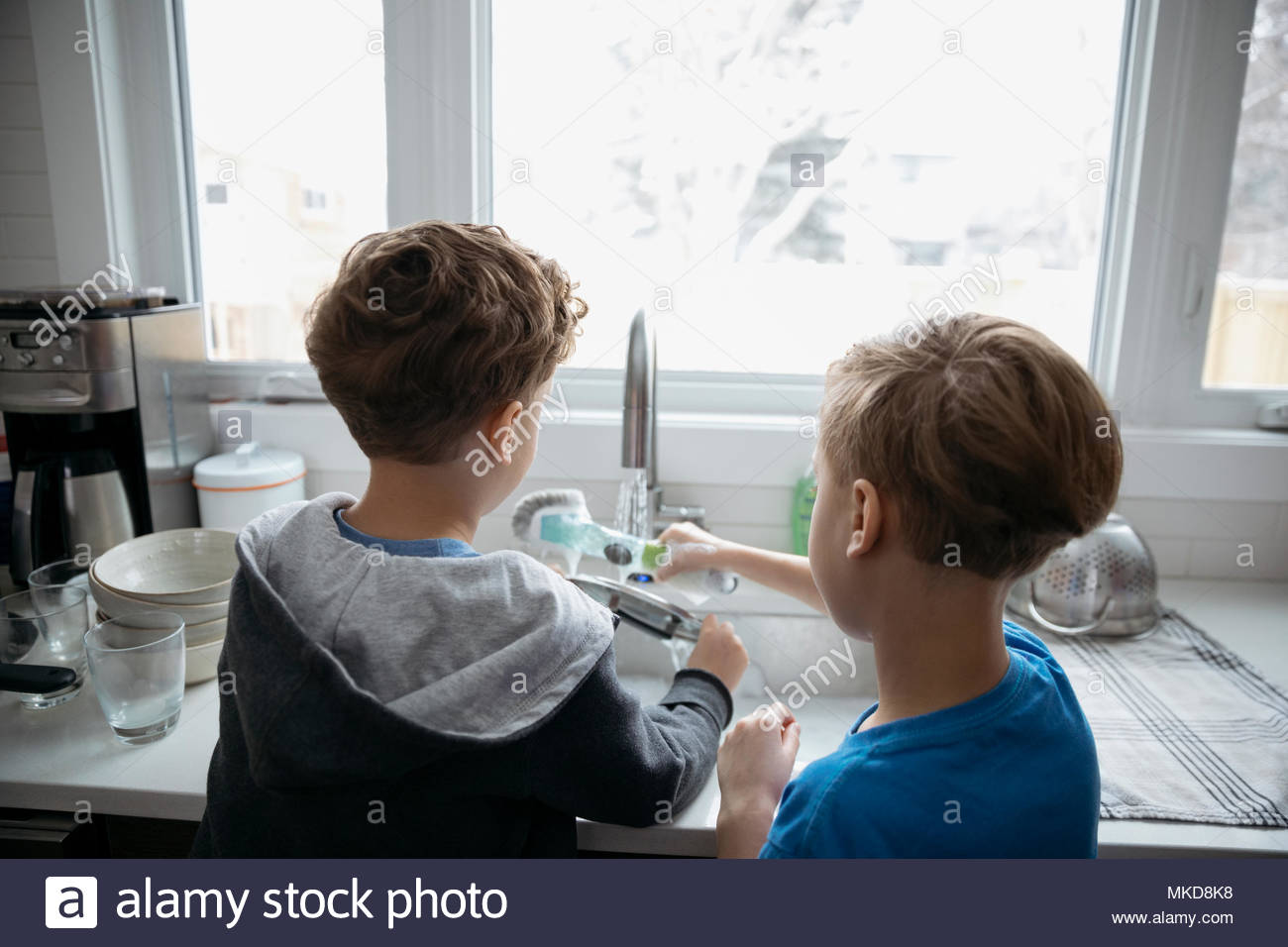 Brothers doing dishes at kitchen sink Stock Photo Alamy