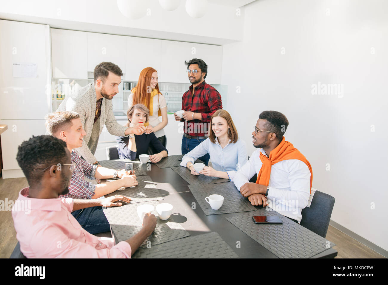 two male employees are having dispute while drinking tea with partners