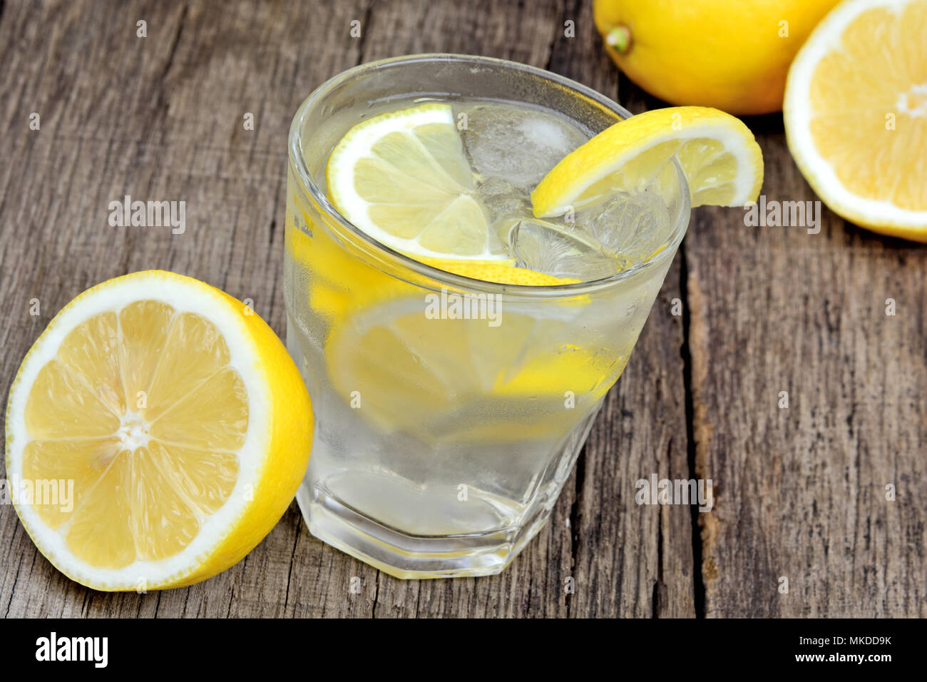 Detox water with fresh lemon and ice cubes in a glass on table Stock Photo
