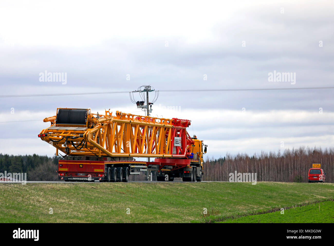 45 metres long oversize transport of Terex lifting equipment on the road. The load requires a pilot car in front of and behind of the long vehicle. Hu Stock Photo