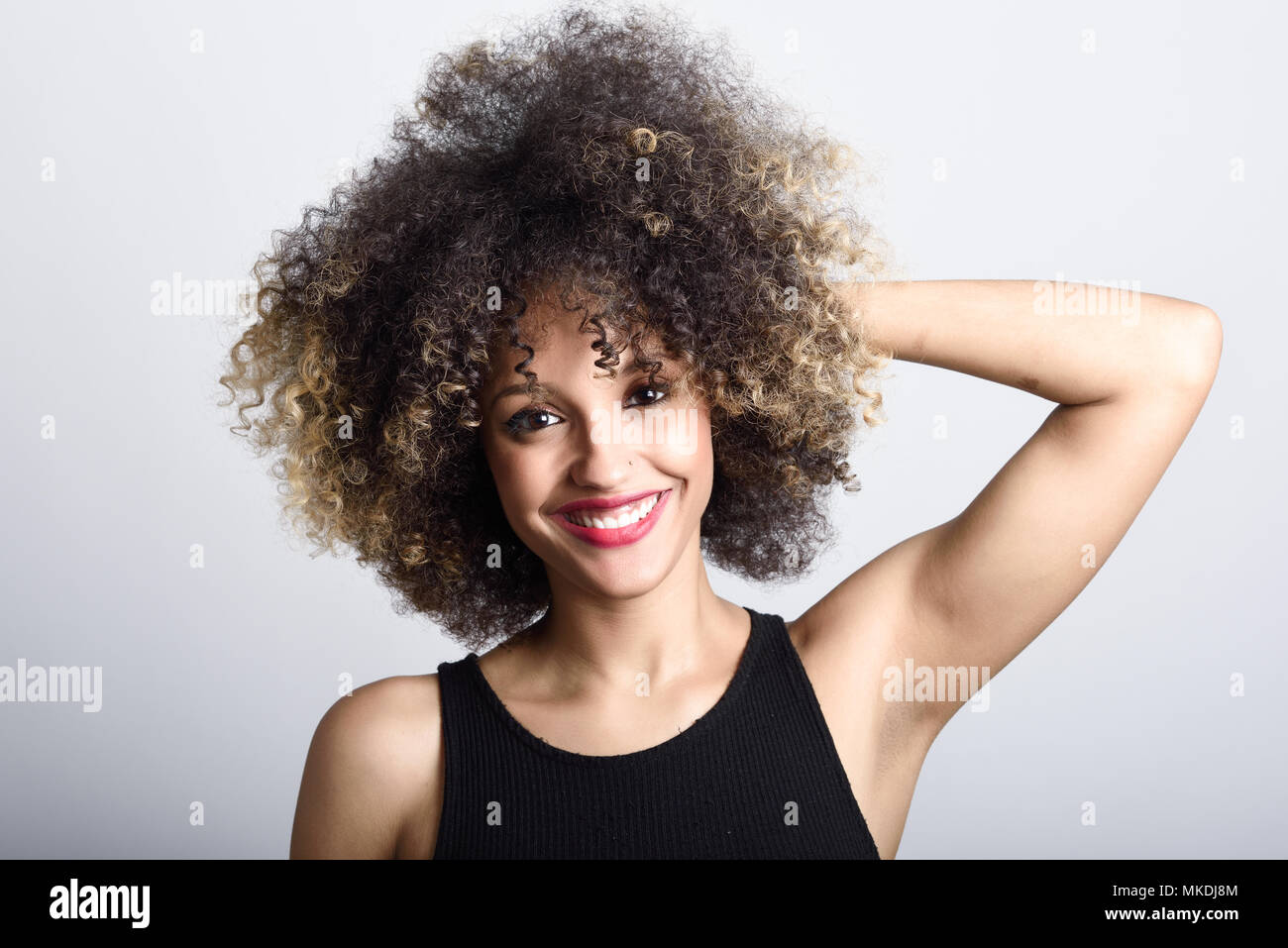 Young black woman with afro hairstyle laughing. Girl wearing black