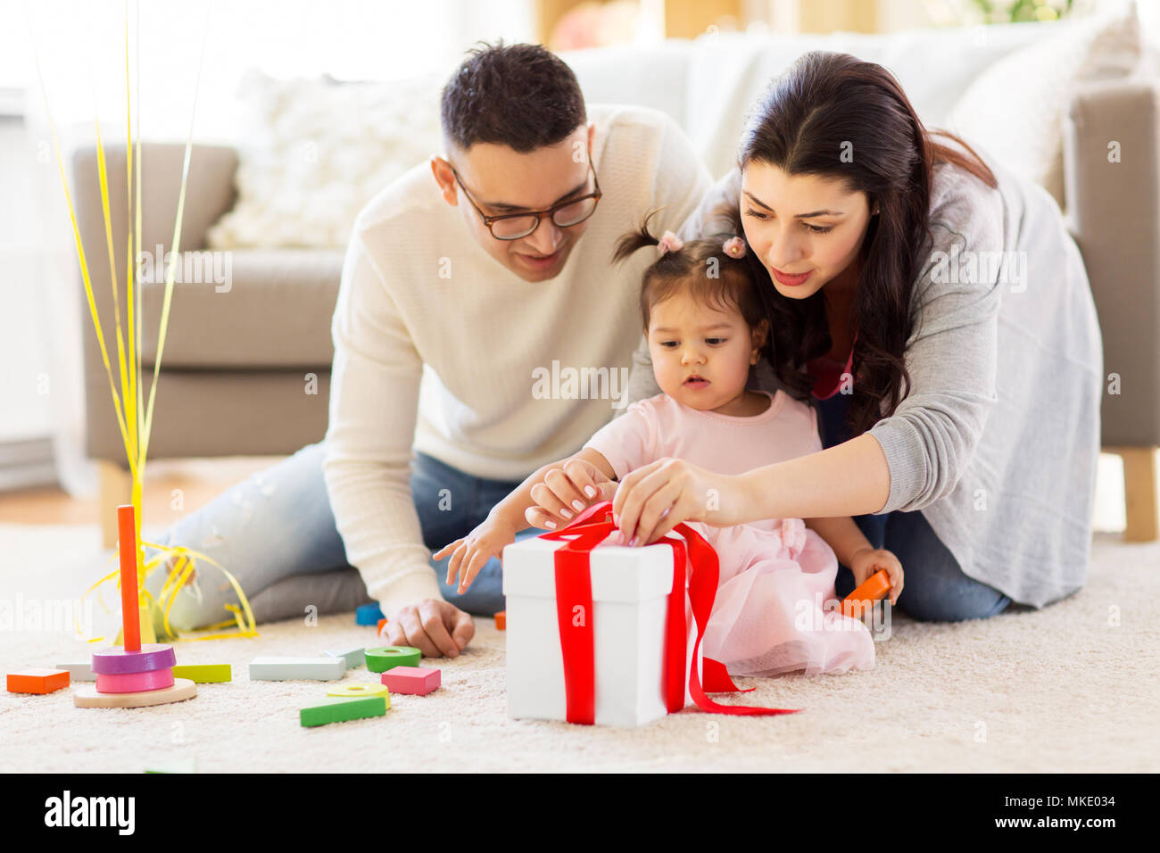 baby girl with birthday gift and parents at home Stock Photo Alamy