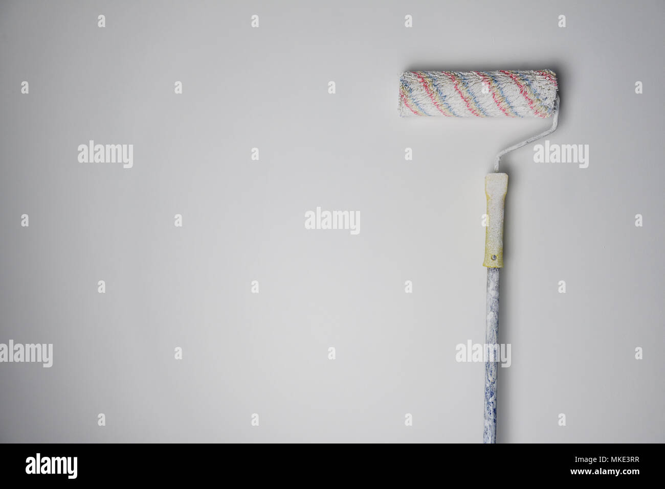 Painting roller on white wall background Stock Photo