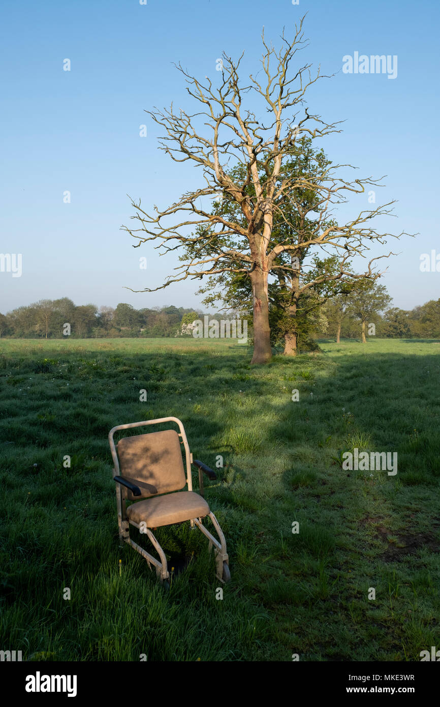 A hospital style wheelchair is left abandoned to litter the English countryside on a public Bridleway track in Worcestershire. Stock Photo