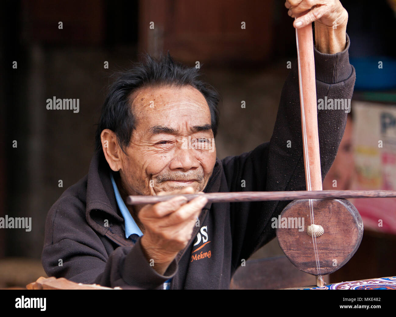 An instrument maker plays a violin he has just completed. Stock Photo
