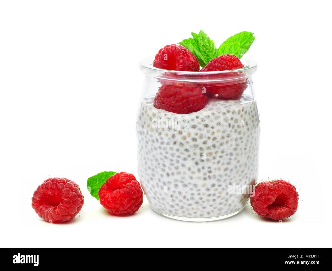 Healthy raspberry chia pudding in a jar with scattered fruit isolated on a white background Stock Photo
