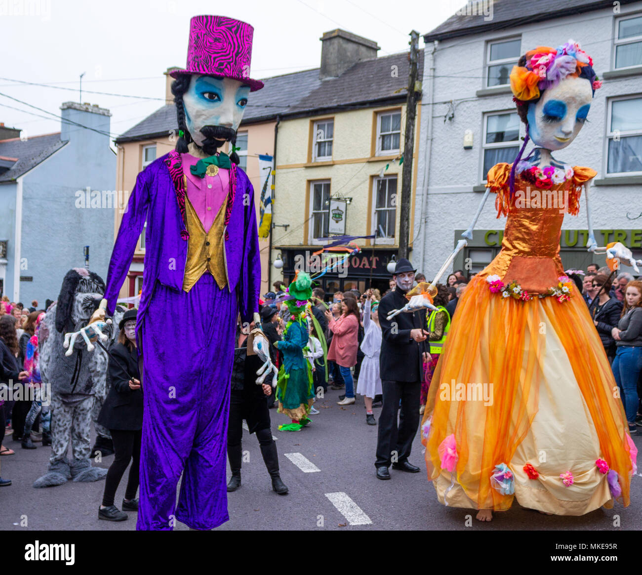 brightly coloured giant puppets taking part in a street procession celebrating an annual jazz festival in ballydehob, ireland. Stock Photo